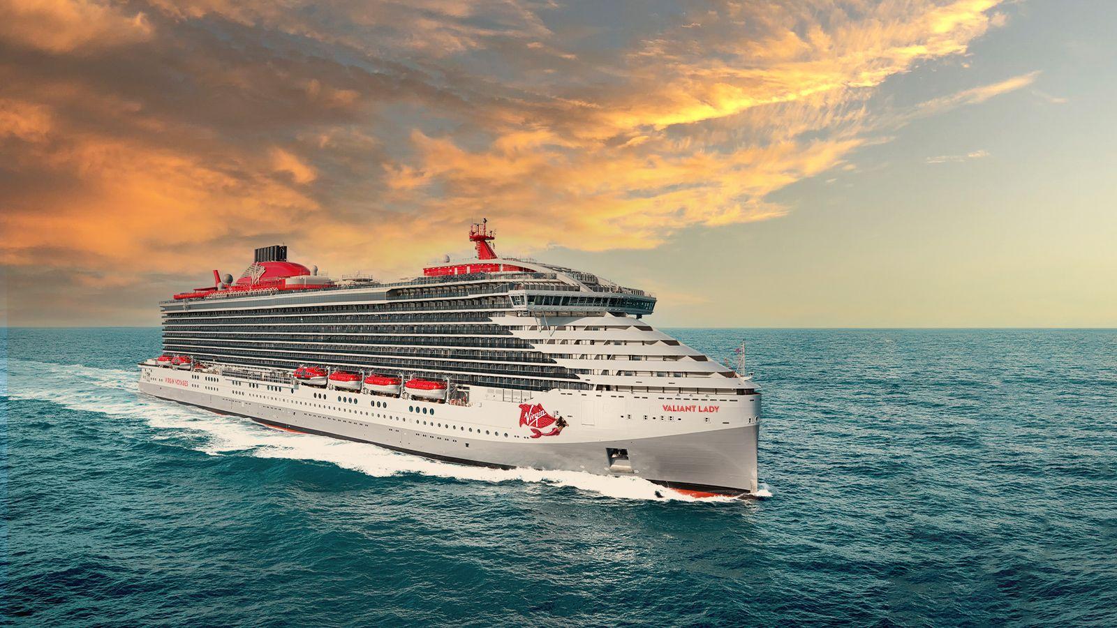 Large cruise ship sailing on the ocean under a dramatic sunset sky.